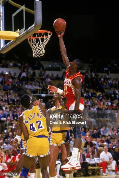 Dominique Wilkins of the Atlanta Hawks goes up for a layup against James Worthy and Kareem Abdul-Jabbar of the Los Angeles Lakers during a 1986 NBA...