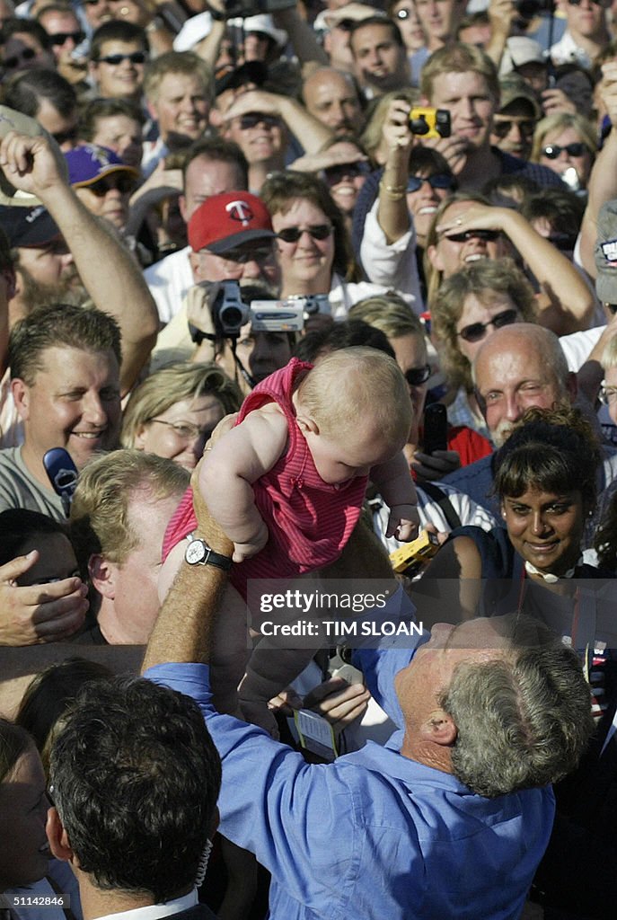 US President George W. Bush holds a baby