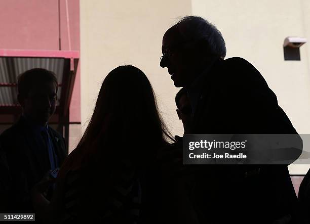 Democratic presidential candidate Sen. Bernie Sanders greets voters standing in line as he visits the Western High School caucus site on February 20,...