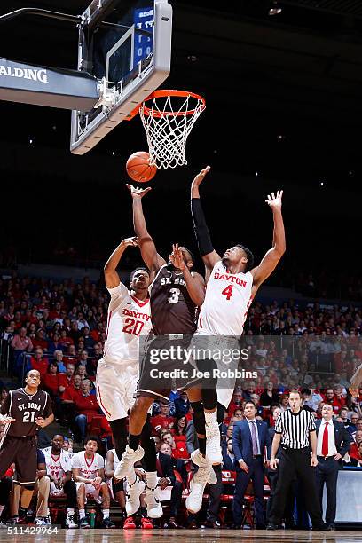 Charles Cooke and Xeyrius Williams of the Dayton Flyers defend against Marcus Posley of the St. Bonaventure Bonnies in the first half of the game at...