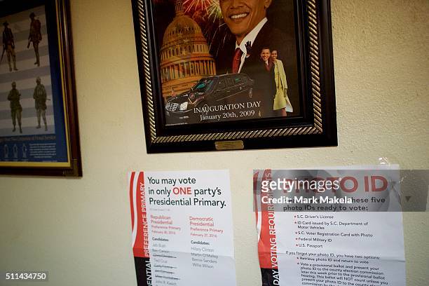 Voting notices are posted below a framed painting commemorating the inauguration of President Barack Obama at the Aiken American Legion Post polling...
