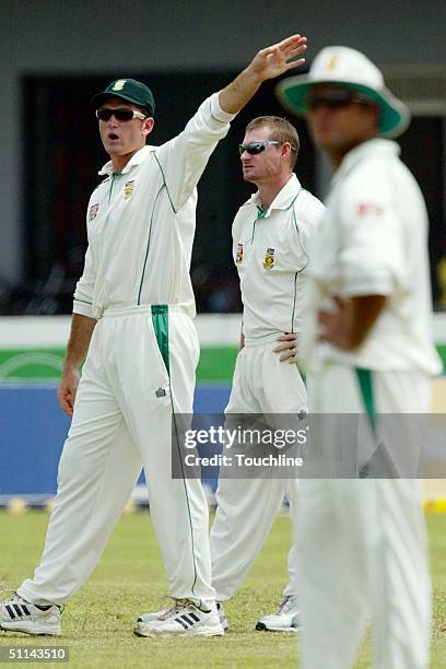 South African captain Graeme Smith moves the field around for new bowler Lance Klusener during the second day of the First Test match between Sri...