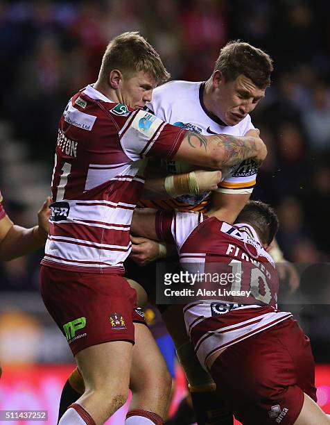 Jarrod Wallace of Brisbane Broncos is tackled by Ryan Sutton and Ben Flower of Wigan Warriors during the World Club Series match between Wigan...