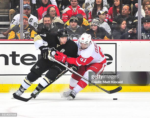 Matt Cullen of the Pittsburgh Penguins and Xavier Ouellet of the Detroit Red Wings skate after the puck at Consol Energy Center on February 18, 2016...