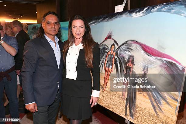 Christine Neubauer and her partner Jose Campos in front of her painting during the 'Christine Neubauer Hautnah' exhibition opening at Hotel Vier...