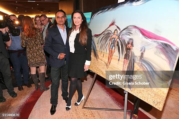 Christine Neubauer and her partner Jose Campos in front of her painting during the 'Christine Neubauer Hautnah' exhibition opening at Hotel Vier...