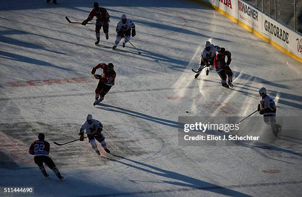 Players of the Chicago Blackhawks Alumni and the Minnesota North Stars/Wild Alumni cast shadows on the ice as they skate up ice during the 2016 Coors...