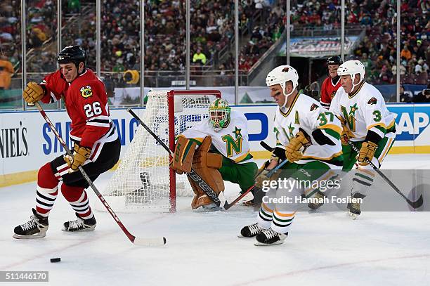 Dave Mackey of the Blackhawks Alumni controls the puck against Wes Walz of the Minnesota Wild Alumni during the alumni game at the 2016 Coors Light...