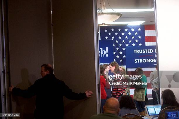 Man opens a dividing wall between the press and Jeb Bush campaign staff members after the former Governor of Florida suspended his presidential bid...