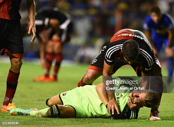 Luis Unsain goalkeeper of Newell's receives assistance from his teammate after being hit on his face during the 4th round match between Boca Juniors...