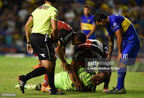 Luis Unsain goalkeeper of Newell's receives assistance from his teammates after being hit on his face by Carlos Tevez during the 4th round match...
