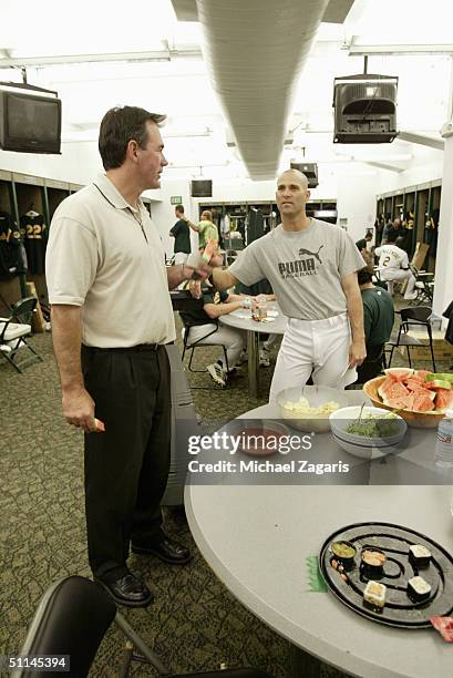 Billy Beane and Tim Hudson of the Oakland Athletics talk in the locker room before the MLB game against the San Francisco Giants at Network...