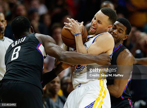 Stephen Curry of the Golden State Warriors battles for a loose ball against Jeff Green and C.J. Wilcox of the Los Angeles Clippers during the second...