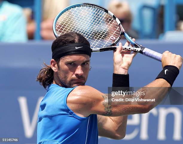 Carlos Moya of Spain returns a ball to Wayne Arthurs of Austria during the Western and Southern Financial Group Masters tournament on August 5, 2004...