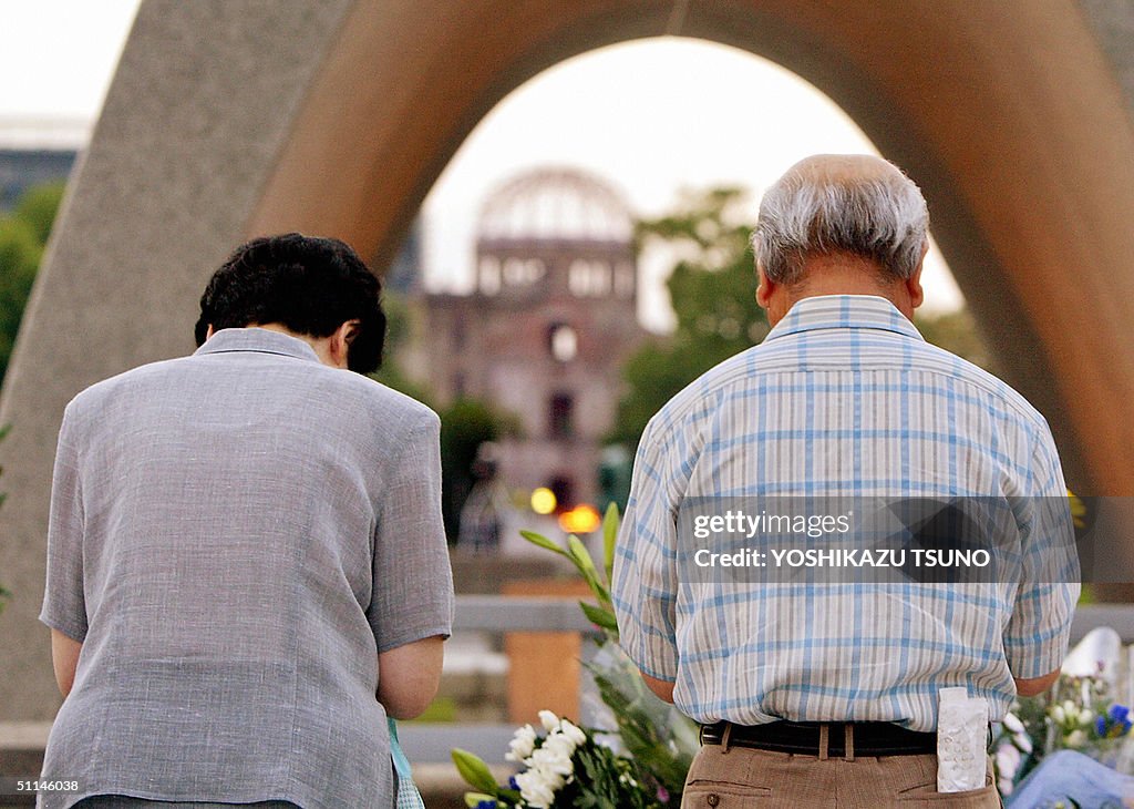 An elderly couple pray together before t