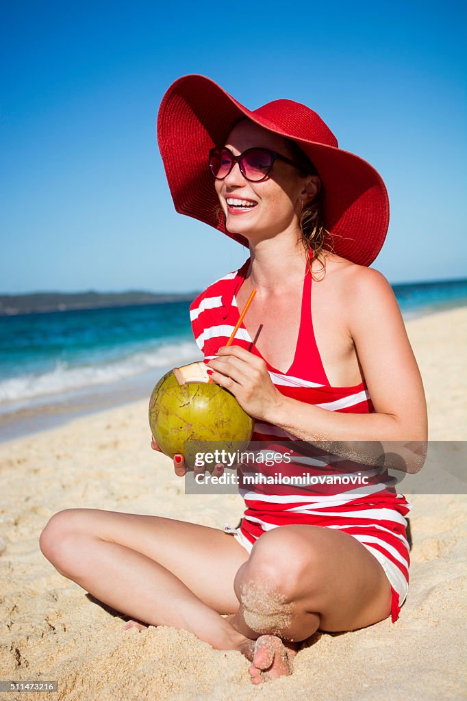 Jeune femme de boire de l'eau de noix de coco