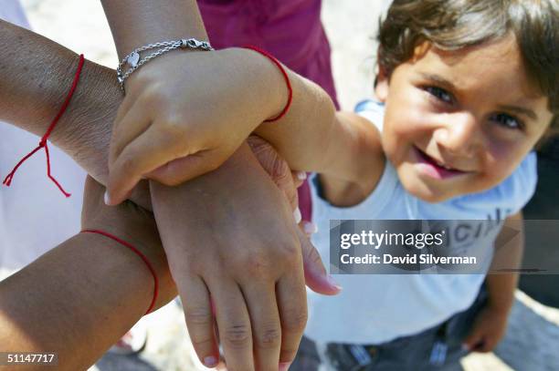 The Saadoun family from Paris, France, show the Kabbalah Red String Bracelets they wear while praying at the Western Wall, Judaism's holiest site,...