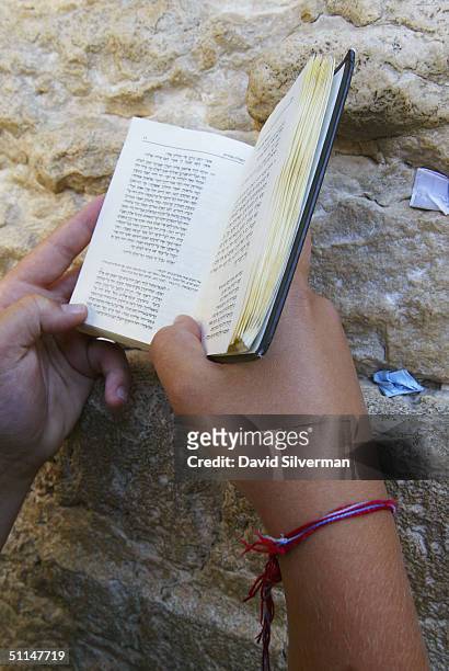 Year-old Jewish youth from Long Island, New York, wears his Kabbalah Red String Bracelet while praying at the Western Wall, Judaism's holiest site,...