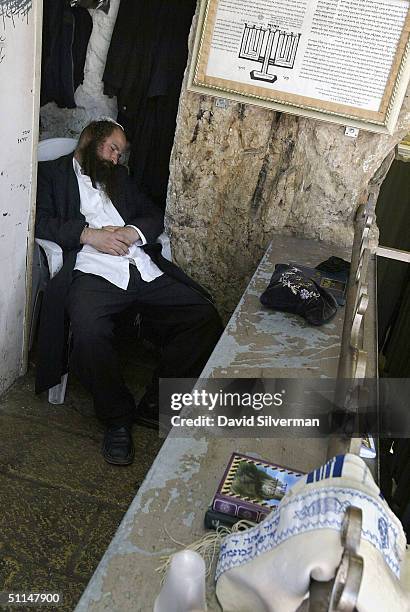 An ultra-Orthodox Jew sleeps after praying through the night in the cave tomb of Rabbi Shimon HaTzadik , one of the earliest high priests of the...