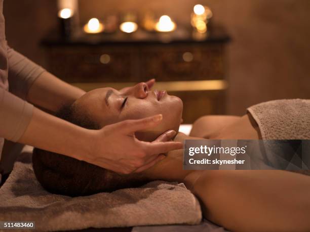 afroamericana en el spa mujer recibiendo un masaje facial. - black massage therapist fotografías e imágenes de stock