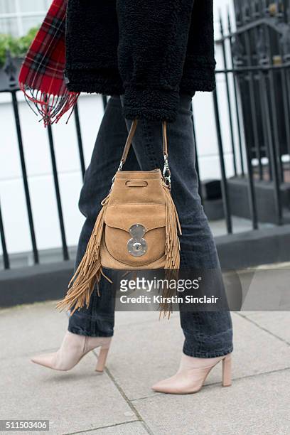 Fashion editor and blogger Adenorah wears Levi's jeans, River Island scarf and bag, Zoe Jordan jacket and Stella Luna boots on day 2 during London...