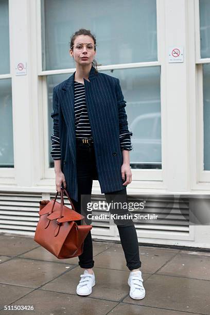 Fashion Blogger Irina Lakicevic wears a Ganni jacket, Saint Laurent jeans and belt, Celine top and bag and Adidas shoes on day 2 during London...
