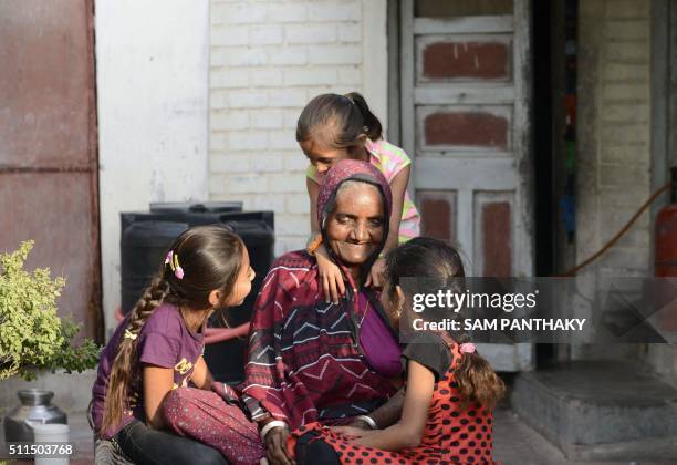 An Indian elderly woman interacts with her granddaughters in Suraj in Mehsana district, some 100 km from Ahmedabad, on February 20, 2016. A village...