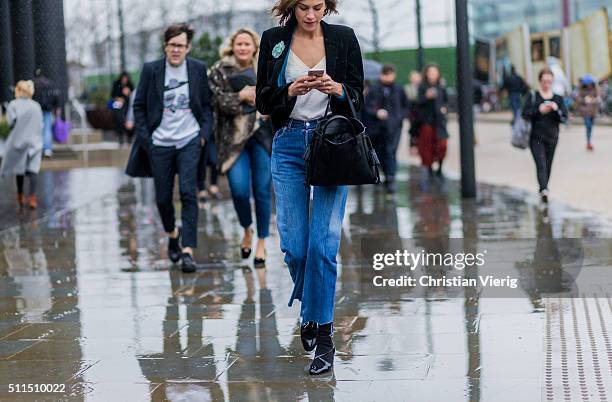 Alexa Chung wearng a dark green velvet blazer a white blouse and a blue denim jeans seen outside Emilia Wickstaed during London Fashion Week...