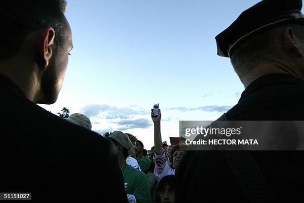 Woman raises her celphone to make her relatives listen to the speech of Democratic Presidential Candidate John Kerry in Las Vegas, New Mexico 07...