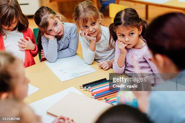 preschool teacher and children in classroom - answering stock pictures, royalty-free photos & images