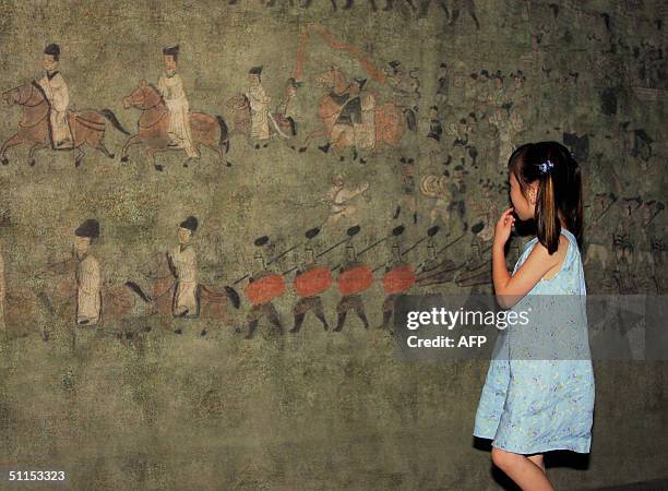 South Korean girl inspects the replica of a mural from the tomb of Koguryo, an ancient state that disappeared more than 1,000 years ago, in a...
