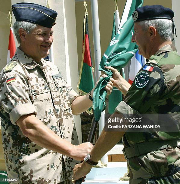 Joint Force Command Commander, Gerhard Back, hands a flag to the Commander of Eurocorps French Lieutenant General Jean-Louis Py during a ceremony,...