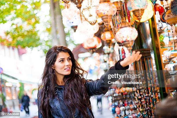 young turkish woman shopping for street goods - asian market stock pictures, royalty-free photos & images