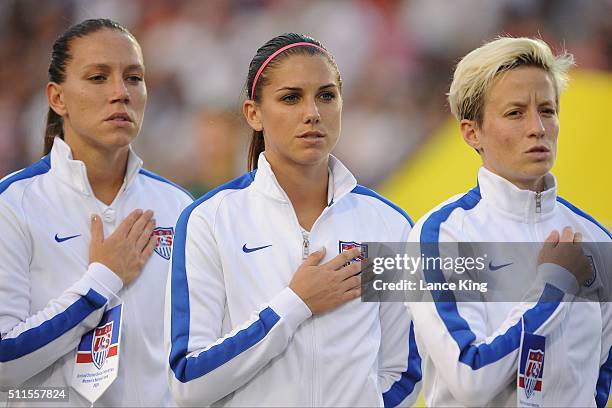 Lauren Holiday, Alex Morgan and Megan Rapinoe of the U.S. Women's national team stand at attention during the National Anthem prior to their match...