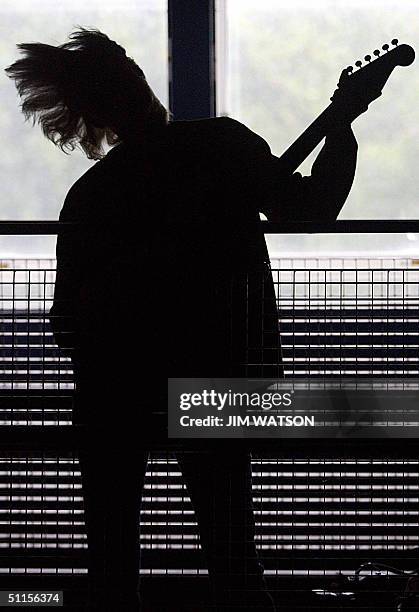 Model Mari-Liis Ivalo swings here hair around as she holds Jimi Hendrix's vintage 1965 Fender Statocaster, worth an estimated GBP 250 during a press...