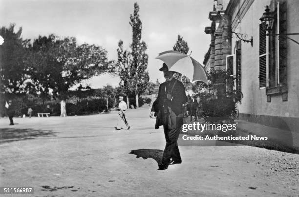 Italian composer, Giuseppe Verdi walking with a parasol in Montecatini Terme, Italy, 1892.