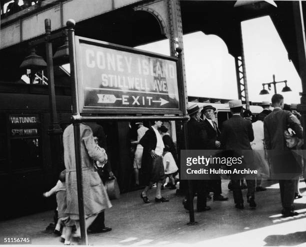 View of commuters as they walk along the platform after getting off a train at the Stilwell Avenue BMT stop at Coney Island, New York, 1920s.