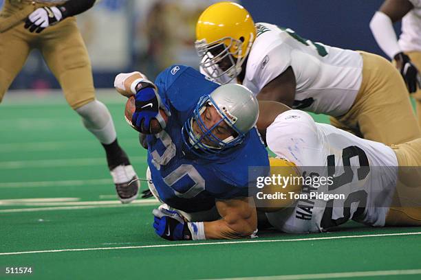 Cory Schlesinger of the Detroit Lions is tackled by Bernardo Harris of the Green Bay Packers during the game at Pontiac Silverdome in Pontiac,...