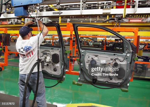 Worker assembles car door units at Ford's Chicago Assembly Plant August 10, 2004 in Chicago, Illinois. Ford previewed to the news media the Chicago...