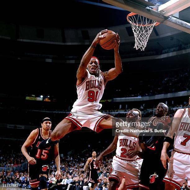 Dennis Rodman of the Chicago Bulls rebounds against Chris Gatling of the Miami Heat during a game at The United Center on April 26, 1996 in Chicago,...