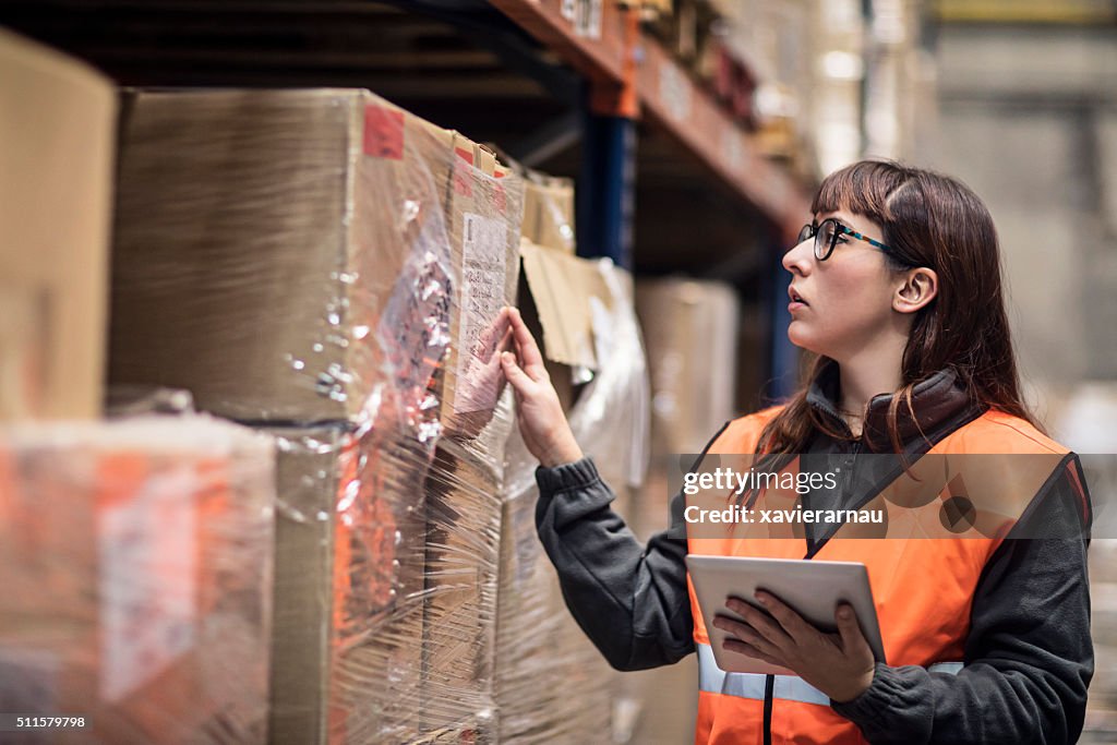 Worker checking box in warehouse