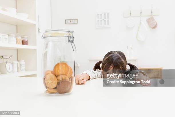 girl looking at cookies - child cookie jar stock pictures, royalty-free photos & images