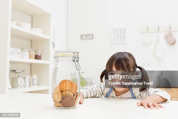 girl looking at cookies - child cookie jar stock pictures, royalty-free photos & images