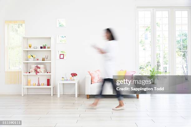 woman walking in living room - blurry living room stockfoto's en -beelden