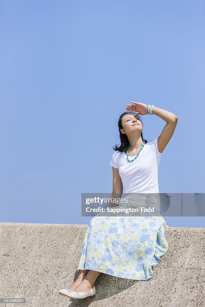 Woman Sitting On Breakwater