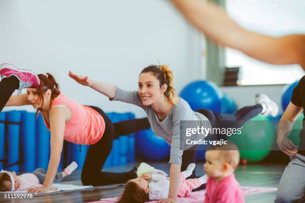 parents exercising with their babies in a gym - practicing stock pictures, royalty-free photos & images