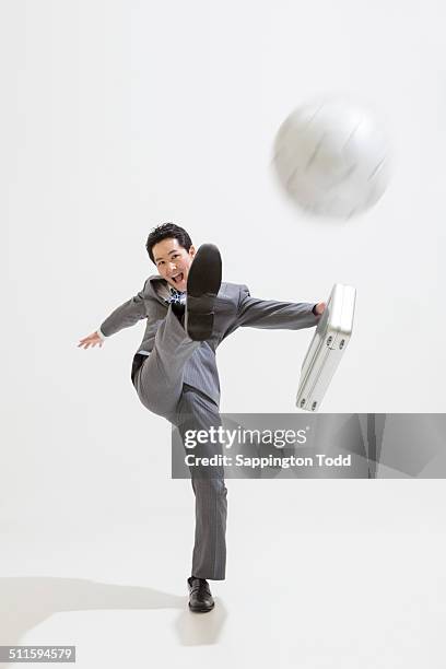 businessman kicking football - kicking bag stock pictures, royalty-free photos & images