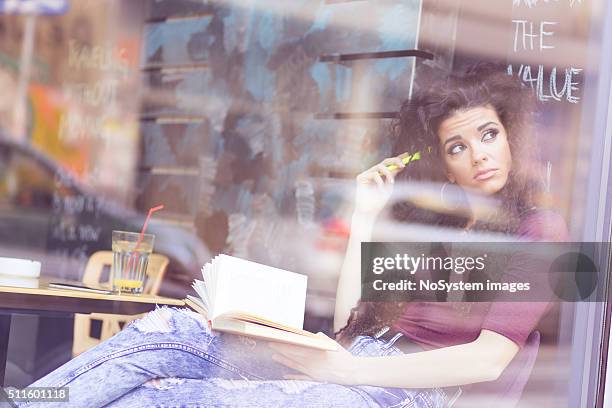 adolescente, cheveux bouclés fille lisant un livre dans un café - straw hair photos et images de collection