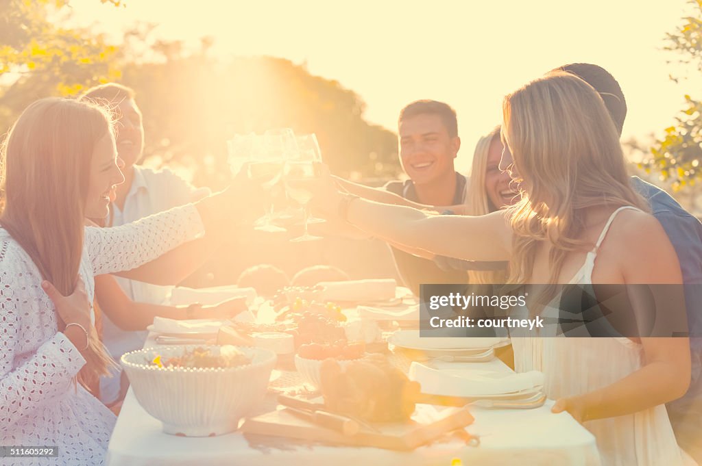 Group of friends having drinks at sunset.