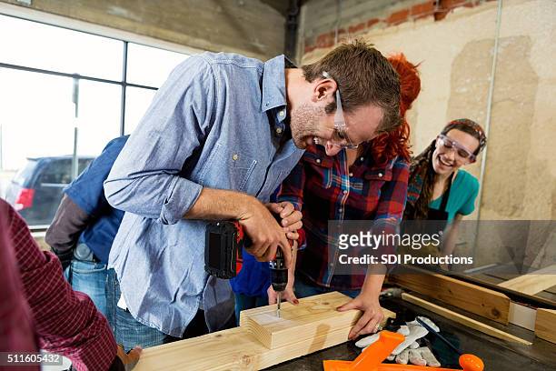 young caucasian man uses power drill in workshop - carving craft activity bildbanksfoton och bilder